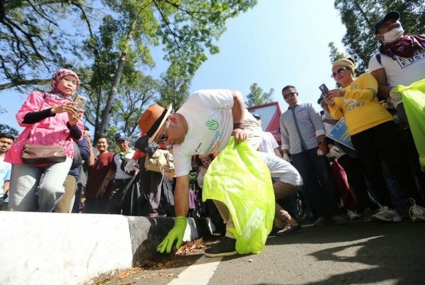 Wali Kota Bandung Ridwan Kamil memungut sampah  bersama ratusan warga di Car Free Day Dago, Ahad (8/10).