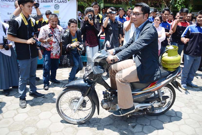  Wali Kota Bandung, Ridwan Kamil mencoba sepeda motor berbahan bakar gas elpiji karya siswa SMKN 8 Bandung, Kamis (31/10).   (Republika/Edi Yusuf)