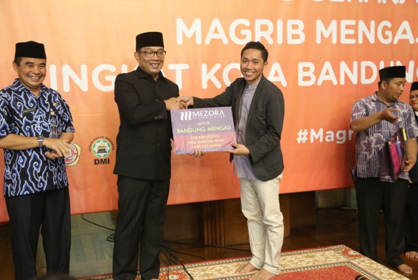 Wali Kota Bandung, Ridwan Kamil, menerima bantuan juzz amma dan mukena yang menjadi program Maghrib Mengaji