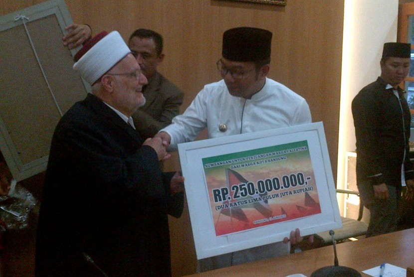 Wali Kota Bandung Ridwan Kamil menyerahkan bantuan senilai Rp 250 juta untuk rakyat Palestina melalui Imam Besar Masjid Al Aqsha Syeikh Ikrimah di Pendopo Kota Bandung, Ahad (12/6).