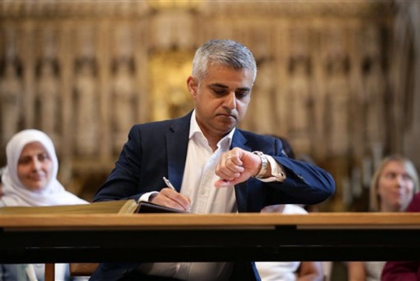 Wali Kota baru London Sadiq Khan melihat jam tangannya dalam upacara penandatanganan jabatannya di Katedral Southwark, London, Sabtu 7 Mei 2016.