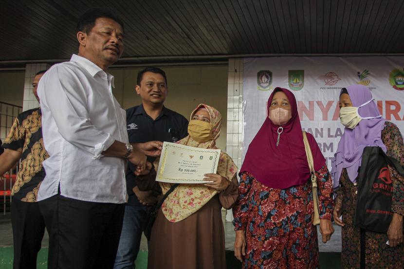 Wali Kota Batam sekaligus Kepala BP Batam Muhammad Rudi (kiri) secara simbolis menyerahkan Bantuan Langsung Tunai (BLT) Bahan Bakar Minyak (BBM) dan Bantuan Program Sembako kepada warga di Kantor Pos Pusat Batam Centre, Batam, Kepulauan Riau, beberapa waktu lalu.