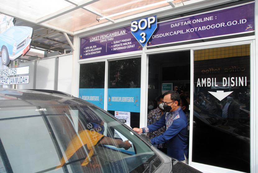 Wali Kota Bogor Bima Arya Sugiarto melayani warga saat peresmian loket layanan tanpa turun (drive thru) di Disdukcapil, Kota Bogor, Jawa Barat, Jumat (26/11/2021).