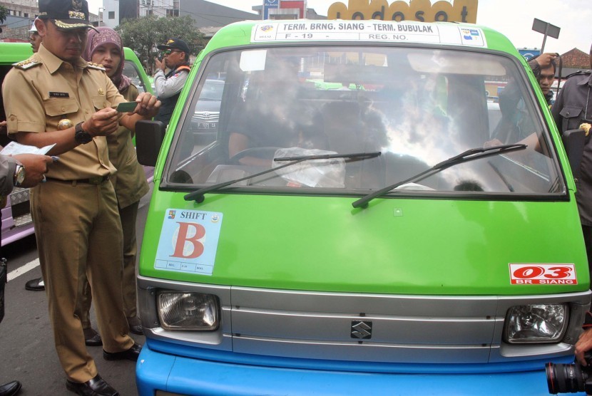 Wali Kota Bogor Bima Arya memeriksa kelengkapan surat saat razia terhadap angkutan kota (angkot) di Jalan Juanda, Kota Bogor, Jawa Barat.