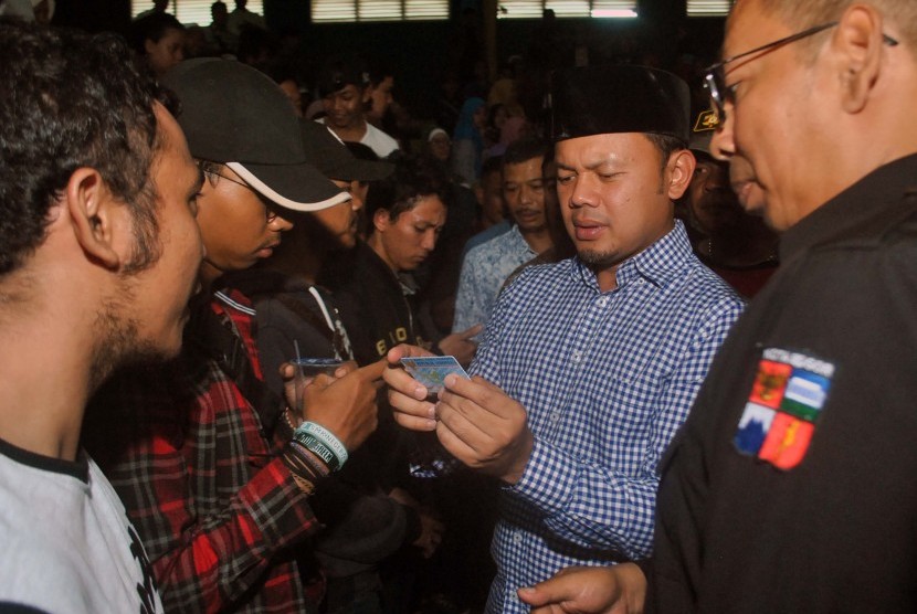 Wali Kota Bogor Bima Arya (tengah) menyerahkan KTP-elektronik yang sudah dicetak kepada warga saat pembagian KTP-elektronik secara serentak di Hall A GOR Pajajaran, jalan Pemuda, Kota Bogor, Jawa Barat, Minggu (5/11). 