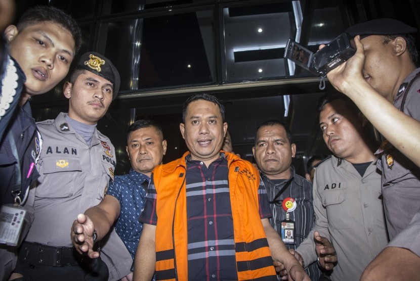 Wali Kota Cilegon Tubagus Iman Ariyadi (tengah) menggunakan rompi tahanan, berjalan seusai menjalani pemeriksaan di Gedung KPK, Jakarta, Minggu (24/9).