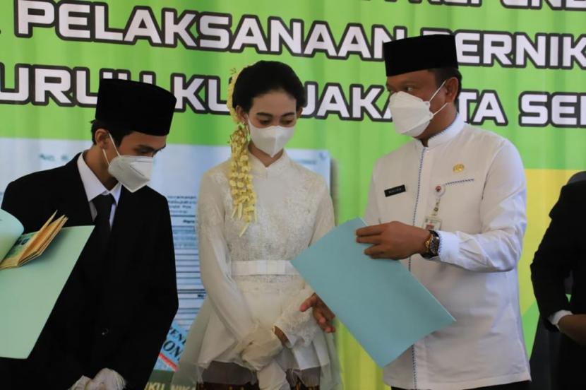 Wali Kota Jakarta Selatan (Walkot Jaksel), Munjirin menyerahkan dokumen kepada pasangan yang menikah.