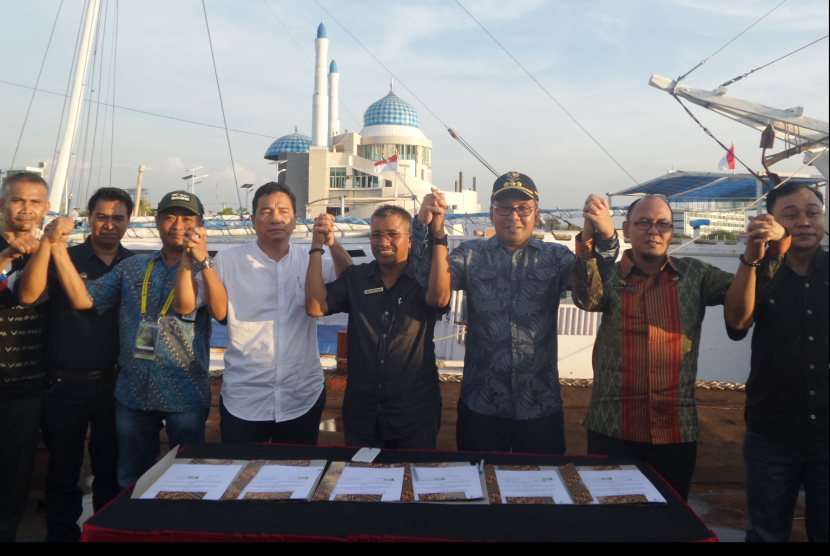 Wali Kota Makassar, Danny Pomanto menandatangani nota kesepahaman (MoU) di atas tongkang di lepas Pantai Losari, Makassar, Sulsel, Jumat (9/9).