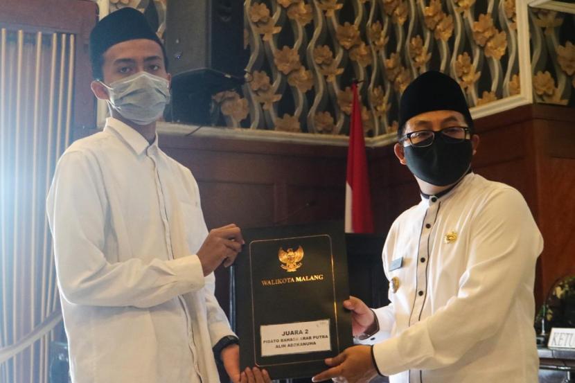 Wali Kota Malang, Sutiaji (kanan) memberikan penghargaan kepada santri berprestasi di Balai Kota Malang, Kamis (22/10). 