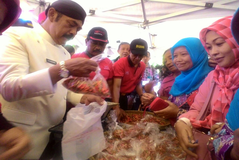 Wali Kota Solo, F.X Hadi Rudyatmo tengah melayani warga yang membeli cabai di Pasar Murah yang digelar TPID Kota Solo pada Kamis (23/2). 