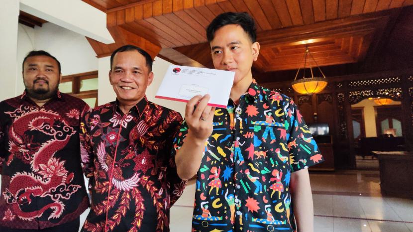 Wali Kota Solo Gibran Rakabuming menunjukkan surat undangan acara Apel Siaga Pemenangan Ganjar Pranowo dari PDIP Jateng.