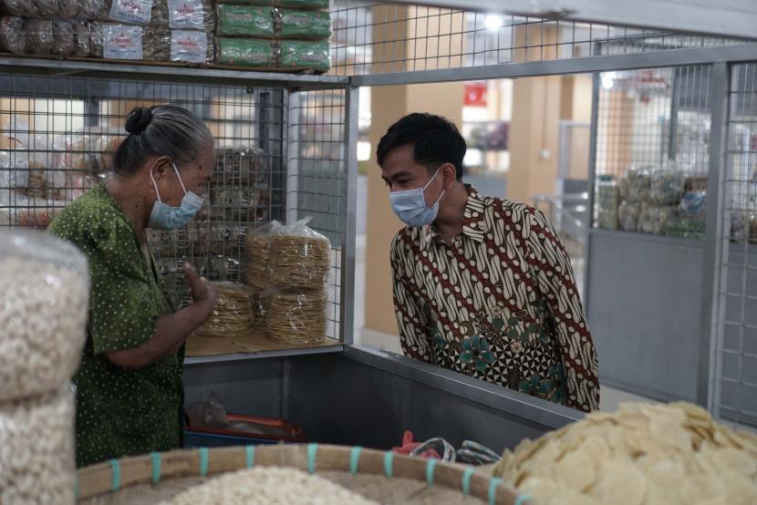 Wali Kota Solo Gibran Rakabuming Raka (kanan) berbincang dengan seorang pedagang saat kunjungan ke Pasar Legi di Solo, Jawa Tengah.