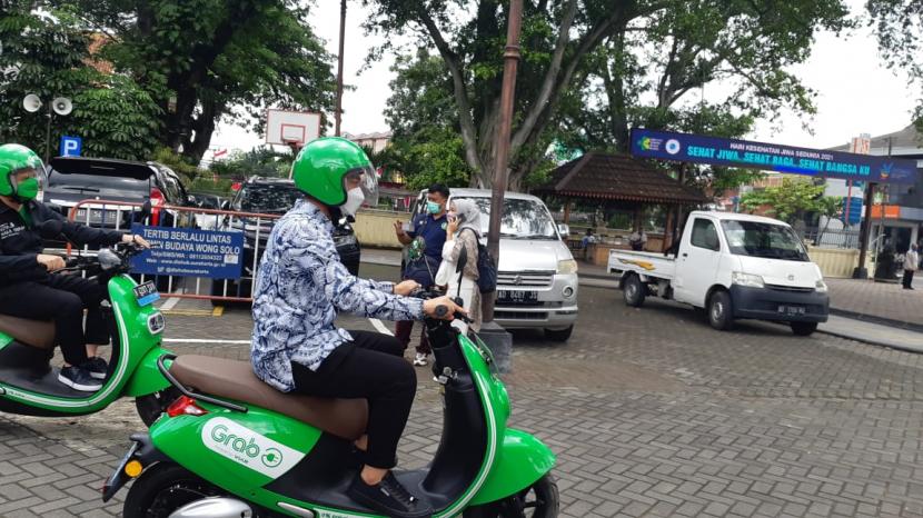 Wali Kota Solo, Gibran Rakabuming Raka, mencoba mengendarai motor listrik untuk mitra pengemudi Grab dari halaman Balai Kota Solo menuju Pasar Gede, Kamis (23/12). 