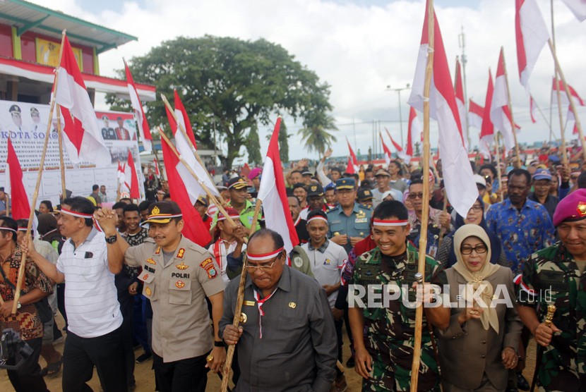 Wali Kota Sorong, Lambertus Jitmau (empat kanan) bersama Forkopimda membawa bendera Merah Putih menyerukan perdamaian di Lapangan Hokky Kota Sorong, Papua Barat, Jumat (6/9/2019). 