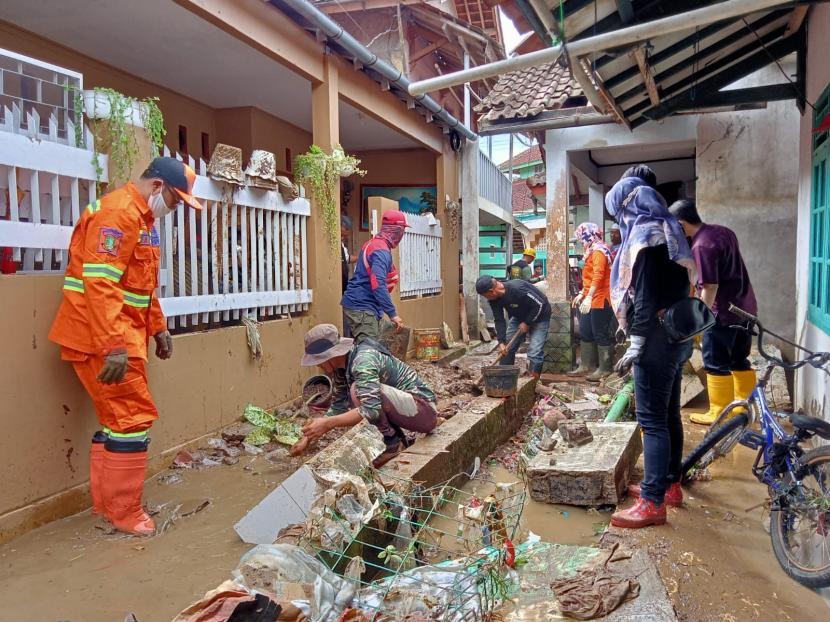 Wali Kota Sukabumi Achmad Fahmi bergotongroyong membersihkan material barang yang terbawa banjir di Kecamatan Baros, Jumat (18/2/2022).