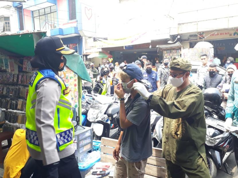 Wali Kota Sukabumi Achmad Fahmi dan Kapolres Sukabumi Kota AKBP Sumarni memakaikan masker kepada warga yang tidak menggunakan masker di Jalan Ahmad Yani, Kota Sukabumi