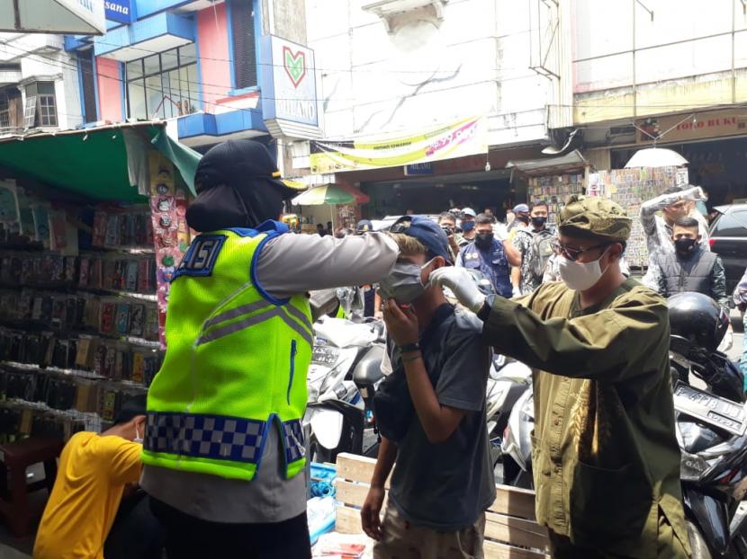 Wali Kota Sukabumi Achmad Fahmi dan Kapolres Sukabumi Kota AKBP Sumarni memakaikan masker kepada warga yang tidak menggunakan masker di Jalan Ahmad Yani, Kota Sukabumi, Kamis (10/9)