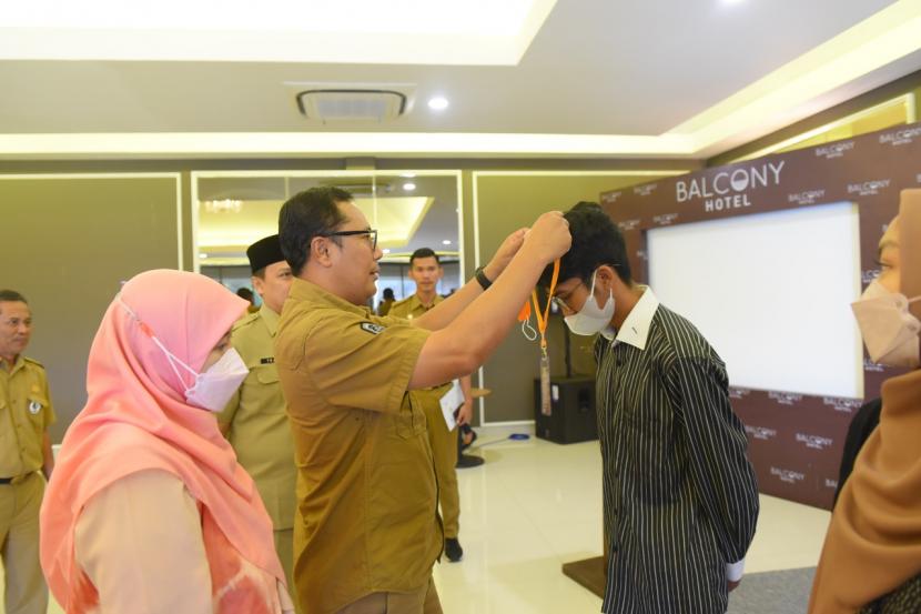 Wali Kota Sukabumi Achmad Fahmi mengalungkan kartu peserta kegiatan penguatan kapasitas untuk membentuk karakter pemuda generasi millenial yang unggul, di Hotel Balcony Sukabumi Selasa (27/9/2022)