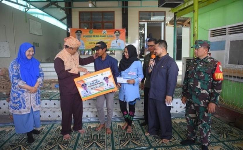 Wali Kota Sukabumi Achmad Fahmi menyerahkan bantuan donasi Udunan Online untuk perbaikan rumah tidak layak huni warga di Kelurahan Cisarua, Kecamatan Cikole, Kota Sukabumi, Jawa Barat, Kamis (27/7/2023).