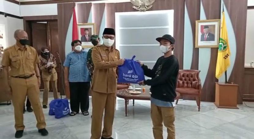 Wali Kota Sukabumi Achmad Fahmi menyerahkan sembako kepada pedagang Dago, penarik becak dan kusir delman di Balai Kota Sukabumi, Senin (19/7).