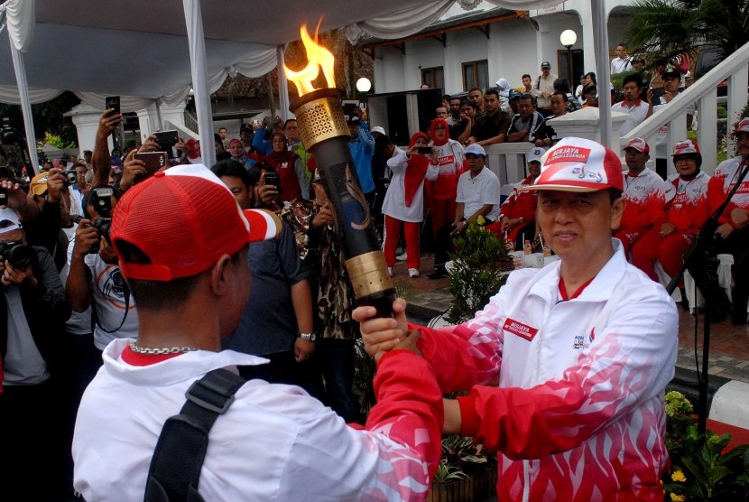 Wali Kota Sukabumi, Mohamad Muraz (kanan) menyerahkan api PON XIX kepada mantan atlet tinju, Veron Matulessy saat Kirab Api PON tiba di Balai Kota Sukabumi, Jawa Barat, Rabu (14/9).