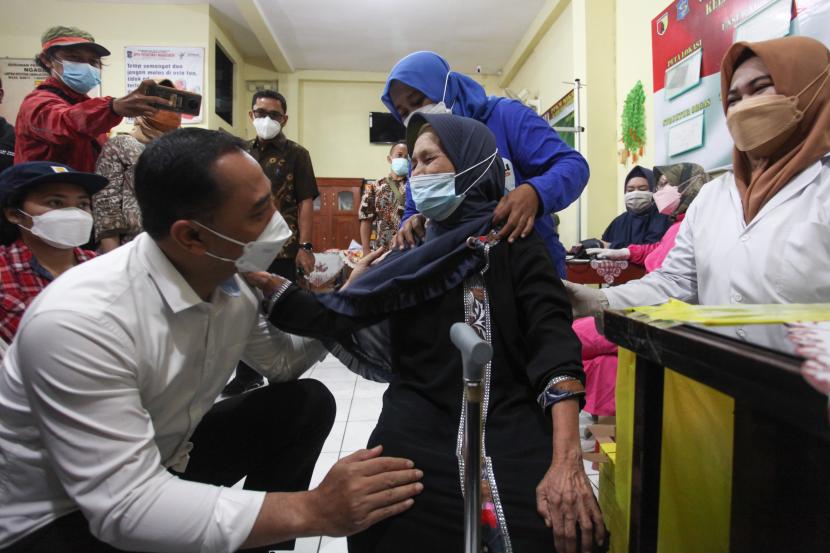 Wali Kota Surabaya Eri Cahyadi (kiri) berbincang dengan warga lanjut usia yang telah mendapatkan suntikan vaksin COVID-19 dosis ketiga (booster) di kawasan Ngagel Mulyo, Surabaya, Jawa Timur, Kamis (13/1/2022).
