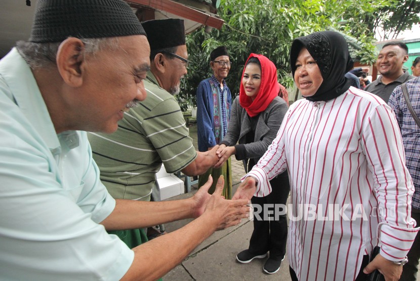 Wali Kota Surabaya Tri Rismaharini (kanan) bersama bakal calon Wakil Gubernur Jawa Timur Puti Guntur Soekarno (kedua kanan) menyapa warga seusai berziarah di Makam Ki Ageng Bungkul, Surabaya, Jawa Timur, Ahad (21/1).