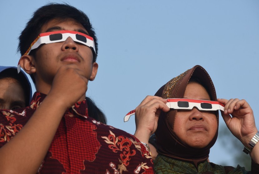 Wali Kota Surabaya Tri Rismaharini (kanan) mengamati gerhana matahari sebagian dengan kacamata khusus di Kenjeran, Surabaya, Jawa Timur, Rabu (9/3).