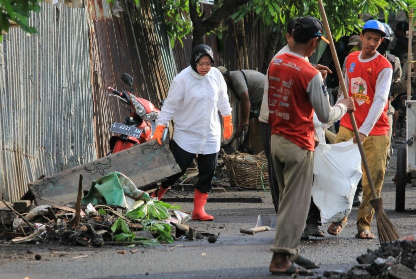 Wali Kota Surabaya Tri Rismaharini (kiri) membersihkan jalan dari sampah di kawasan Jembatan Merah, Surabaya Jawa Timur, Senin (18/7). 