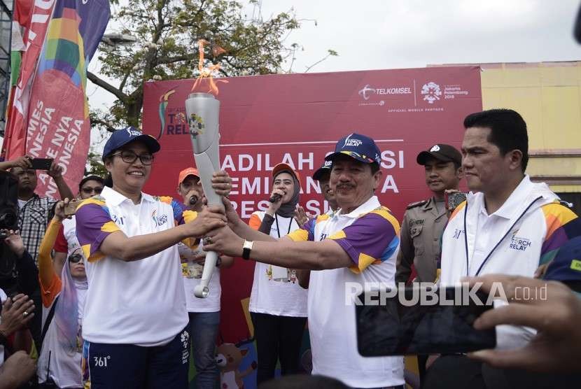 Walikota Bandar Lampung Herman HN (kanan) menyerahkan obor kepada Menteri Keuangan Sri Mulyani (kiri) saat Torch Relay Asian Games 2018 di Bandar Lampung, Lampung, Rabu (8/8).
