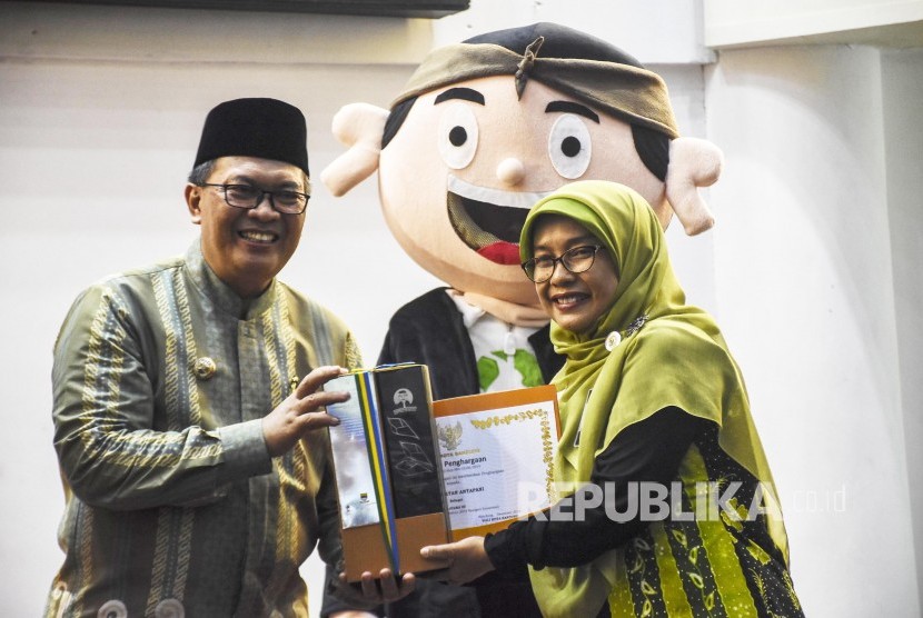 Walikota Bandung Oded M Danial memberikan piagam penghargaan kepada salah satu pemenang pada Festival Kang Pisman di Youth Centre Sport Jabar, Jalan Pacuan Kuda, Arcamanik, Kota Bandung, Jumat (6/12). 