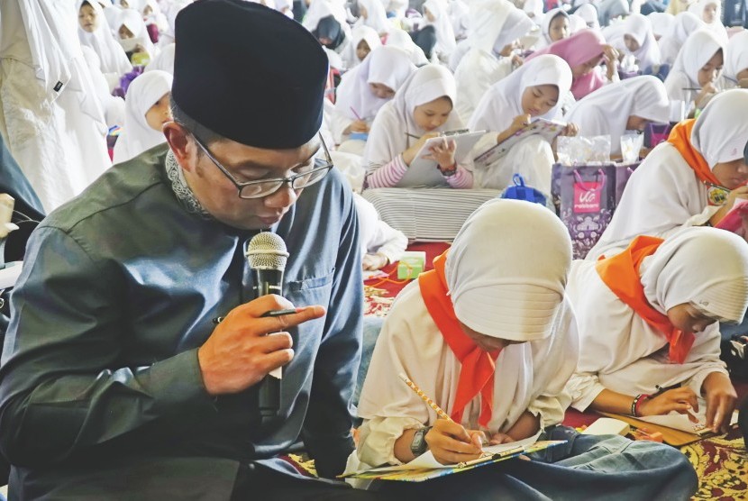 Walikota Bandung, Ridwan Kamil (kiri) memberikan arahan kepada siswa yang mengikuti kegiatan Gerakan Bandung Menulis Alquran di Masjid Agung TSM Bandung, Jawa Barat, Ahad (1/10). 