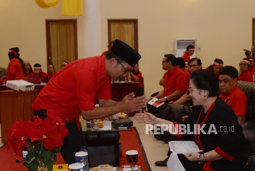  Walikota Bandung Ridwan Kamil (kiri) menyalami Ketua Umum Partai Demokrasi Indonesia Perjuangan (PDIP) Megawati Soekarnoputri (kanan) saat pembukaan Sekolah Partai Calon Kepala dan Wakil Daerah di Depok, Jawa Barat, Selasa (30/8).