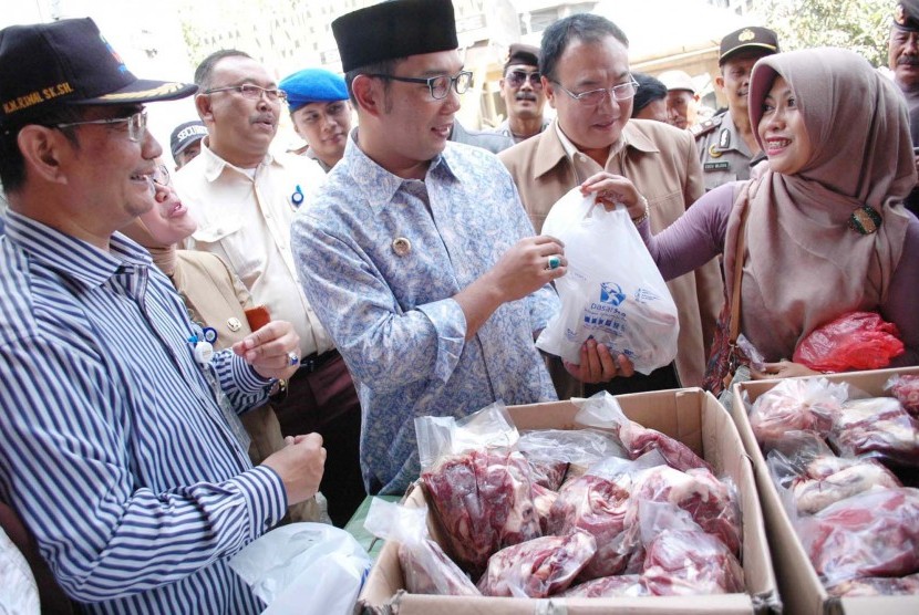 Walikota Bandung Ridwan Kamil melayani pembeli saat sidak Operasi Pasar penjualan daging sapi oleh Bulog, di Pasar Kosambi, kota Bandung, selasa (11/8). Daging sapi dijual Rp 90 ribu per kilogramnya.