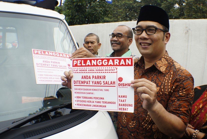 Walikota Bandung Ridwan Kamil menunjukkan stiker pelanggaran kendaraan yang parkir sembarangan di Bandung, Jawa Barat, Jumat (11/3). 