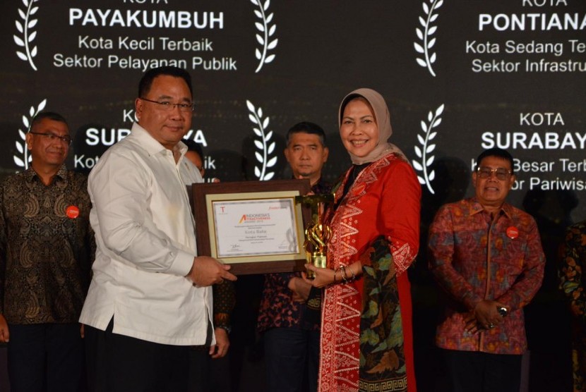 Walikota Batu Dewanti Rumpoko (kanan) saat menerima penghargaan Platinum katagori Kota Pariwisata dari Menteri Desa, Pembangunan Daerah Tertinggal, dan Transmigrasi, Eko Putro Sandjojo (kiri) dalam Indonesia's Attractiveness Award di Hotel Pullman, Jakarta pada Selasa (23/07).