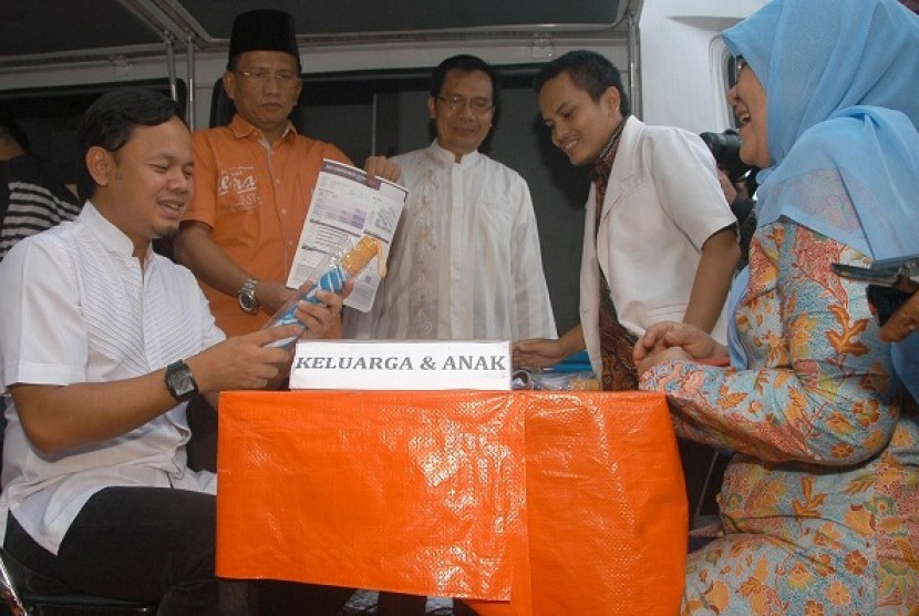 Walikota Bogor Bima Arya (kiri) bersama Wakil Walikota Bogor Usmar Hariman (kedua kiri) mendapat penjelasan tentang hasil analisa gizi saat peluncuran Mobil Curhat di Lapangan Sempur, Kota Bogor, Jabar, Minggu (6/7)