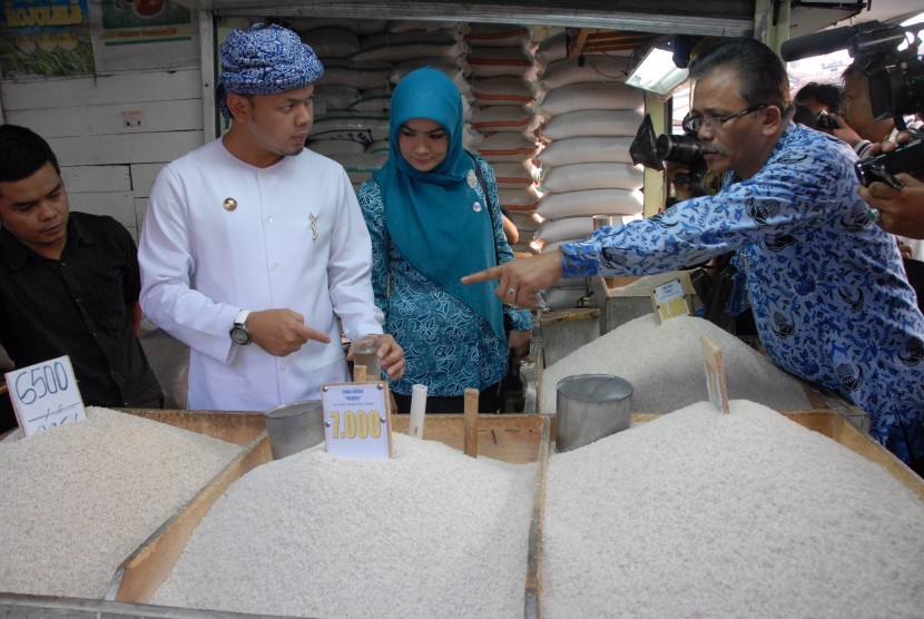 Walikota Bogor, Bima Arya Sugiarto (dua kiri) bersama Kepala Bidang Perdagangan Dinas Perindustrian Perdagangan dan Koperasi Kota Bogor M Sinaga (kanan) memeriksa kualitas dan keamanan beras yang dijual pedagang di Pasar Warung Jambu, Kota Bogor, Jabar, Ra