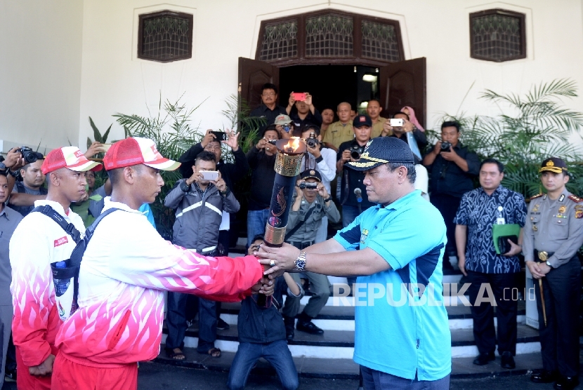 Walikota Cirebon Nasrudin Azis menerima Api Obor PON 2016 dari pasukan pembawa di Gedung Walikota Cirebon, Jawa Barat, Senin (5/9). (Republika/ Wihdan)