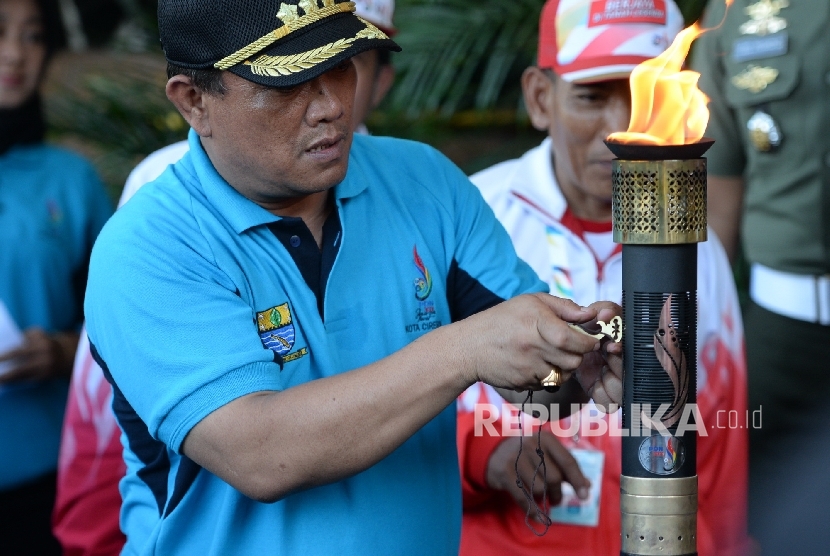 Walikota Cirebon Nasrudin Azis menerima Api Obor PON 2016 dari pasukan pembawa di Gedung Walikota Cirebon, Jawa Barat, Senin (5/9). (Republika/ Wihdan)