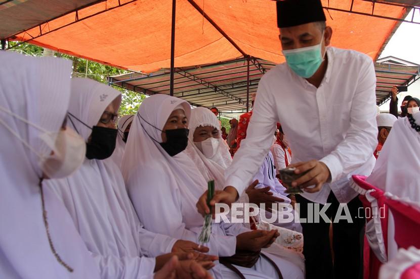 Walikota Dumai Paisal menepung tawari sejumlah calon jemaah umrah di Dumai, Riau, Sabtu (5/2/2022). Sebanyak 35 orang calon jemaah umrah dari Dumai yang sudah divaksin Meningitis dan vaksin COVID-19 akan berangkat ke Jakarta untuk menjalani karantina sebelum diberangkatkan ke Arab Saudi. 