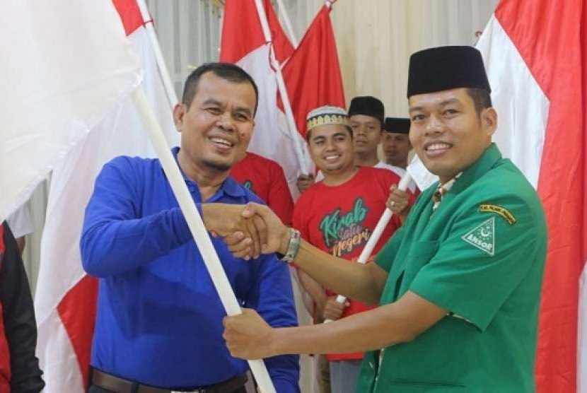 Walikota Pariaman Mukhlis Rahman menerima pataka bendera Merah Putih dari Ketua PC GP Ansor Padang Pariaman Zeki Aliwardana