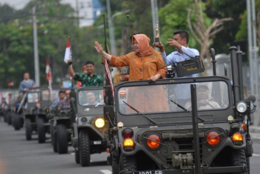 Walikota Surabaya Tri Rismaharini (kedua kanan) mengarak tropi penghargaan Socrates ketika tiba di Balai Kota Surabaya, Jawa Timur, Ahad (20/4).