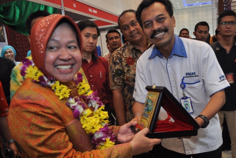 Walikota Surabaya Tri Rismaharini (kiri) menerima plakat dari Pemimpin PT. Permodalan Nasional Madani (Persero) Cabang Surabaya Puji Riyanto (kanan) saat pembukaan Surabaya Great Expo 2015 di Surabaya, Jawa Timur, Rabu (27/5).