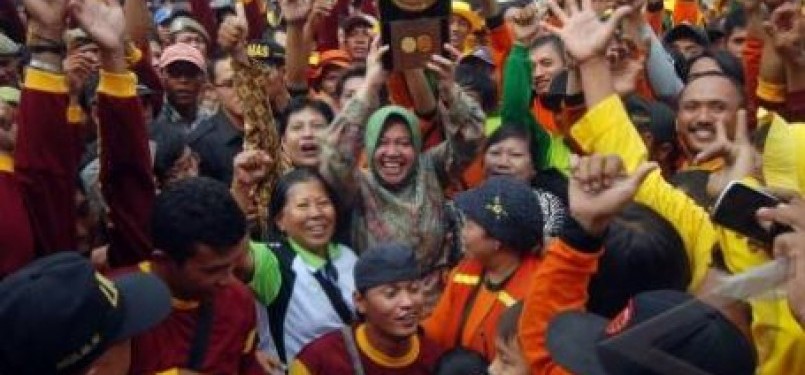 Walikota Surabaya, Tri Rismaharini (tengah), mengangkat penghargaan Adipura bersama sejumlah warga setibanya di Balai Kota Surabaya, Jawa Timur.