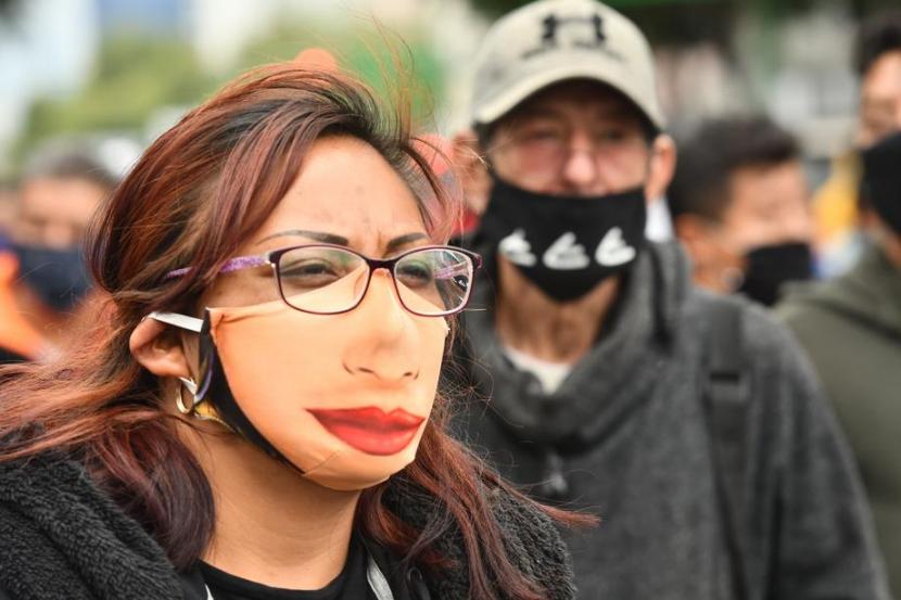 Wanita di Mexico City mengenakan masker. Mexico City berencana melonggarkan kebijakan lockdown.