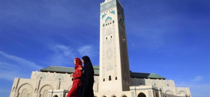 Wanita Maroko berjalan di depan Masjid Hassan II di Casablanca.