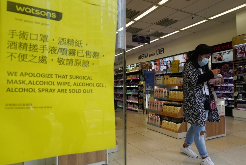 Wanita melewati papan pengumuman yang menerangkan stok masker sudah habis. Mulai Senin (3/2), Hong Kong menutup akses perbatasan dengan China demi menekan penyebaran corona.