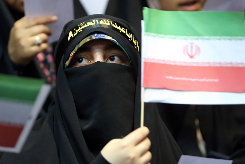Wanita memegang bendera Iran.
