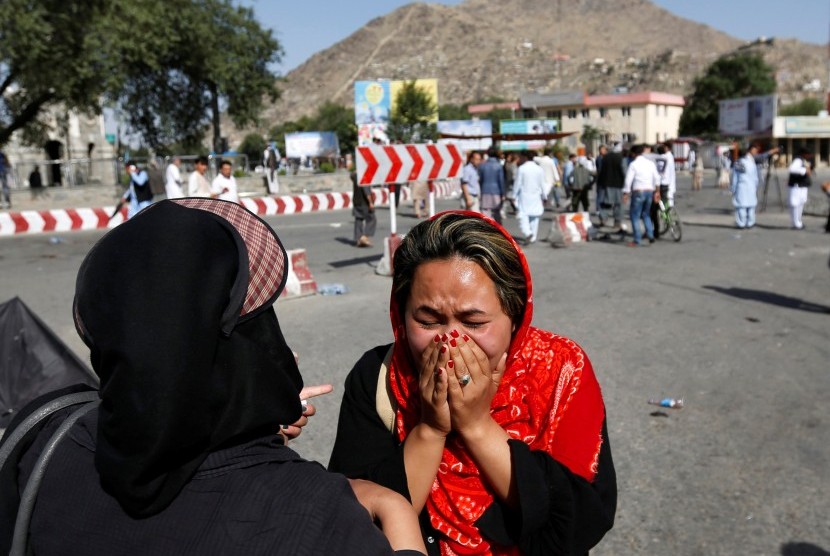 Wanita menangis di lokasi terjadinya ledakan bom bunuh diri di Kabul, Afganistan.